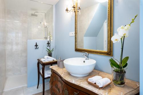 een badkamer met een witte wastafel en een douche bij L'atelier de Hugo in Brussel