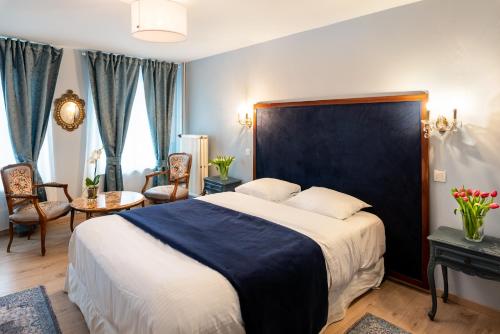 een slaapkamer met een groot bed met een blauw hoofdeinde bij L'atelier de Hugo in Brussel