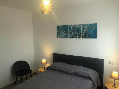 1 dormitorio con 1 cama, 2 lámparas y una pintura en U MANDARINU, en Ajaccio