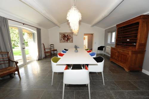 a dining room with a white table and chairs at Domaine de l'Enclos in Gordes