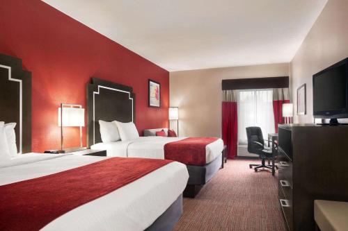 A bed or beds in a room at Days Inn & Suites by Wyndham Murfreesboro