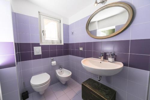 a bathroom with a sink and a toilet and a mirror at Albergo Diffuso Ca' Spiga in Laglio