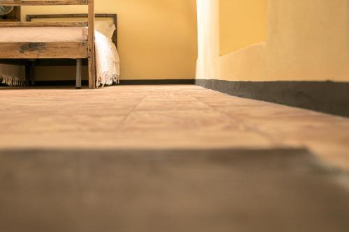 an empty room with a bed and a tiled floor at Albergo Diffuso Ca' Spiga in Laglio