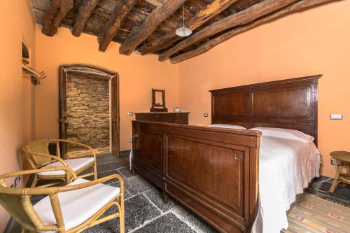 a bedroom with a large bed and two chairs at Albergo Diffuso Ca' Spiga in Laglio