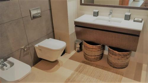 a bathroom with a sink and a toilet at Apartamento de Luxo na Praia in Portimão