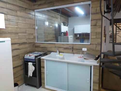 een keuken met een wastafel en een spiegel bij Lofyt em Paraty in Paraty