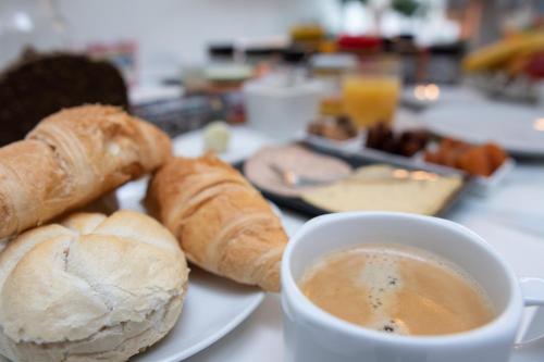 a plate of bread and a cup of coffee on a table at PLANT BASED b&b central Bruges in Bruges