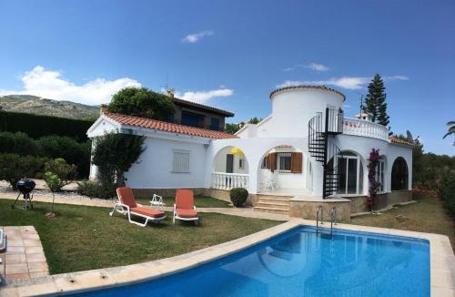a house with a swimming pool in front of it at Villa Cala Blanca in Alcossebre