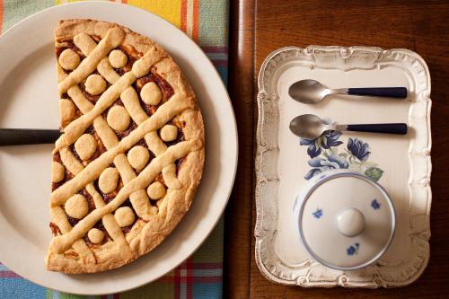 a plate with a pie and a spoon on a table at Albergo Diffuso Ca' Spiga in Laglio