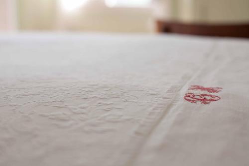 a red spot on a white bedsheet with water on it at Albergo Diffuso Ca' Spiga in Laglio
