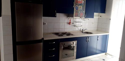 cocina con armarios azules y nevera de acero inoxidable en Spectacular apartment in Skopje, City Mall area en Skopie