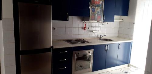 a kitchen with blue cabinets and a stainless steel refrigerator at Spectacular apartment in Skopje, City Mall area in Skopje