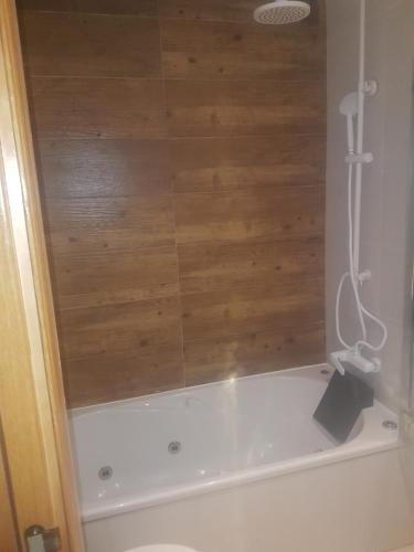 a shower in a bathroom with a wooden wall at Apartamento bahia park 1a linea " Magic world " in Oropesa del Mar
