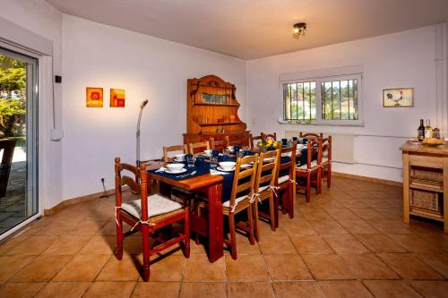 a dining room with a table and chairs at Villa das Palmeiras in Charneca