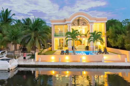 a house on the water with a boat at Hermosa Mansión en Puerto Aventuras con alberca in Puerto Aventuras
