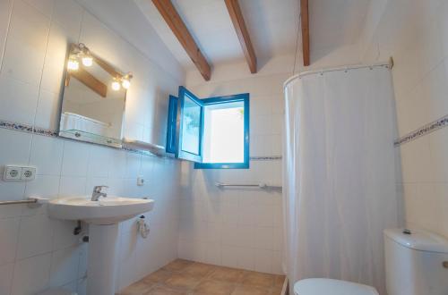 uma casa de banho com um lavatório, um WC e um espelho. em CASA PATRICIA Cala Saona em Cala Saona