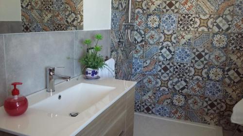 a bathroom with a sink and a tile wall at Mare e Relax in Castellammare del Golfo