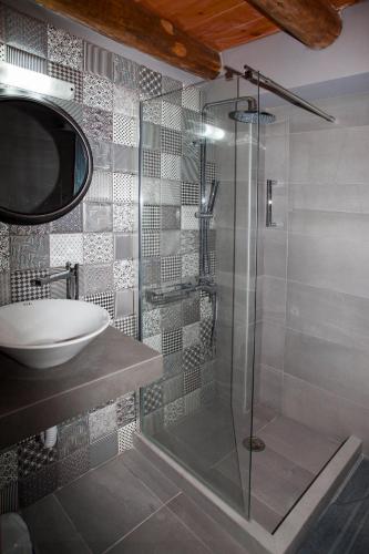 a bathroom with a glass shower and a sink at Ariadne Traditional Home in Margarítai