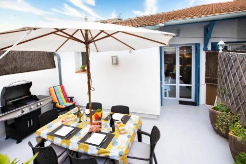 eine Terrasse mit einem Tisch und einem Sonnenschirm in der Unterkunft Les Terrasses Du Midi - Garage+Clim+WiFi in Carcassonne