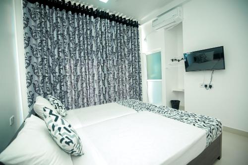 a bedroom with a bed and a curtain at RoaBaa Guesthouse in Batticaloa