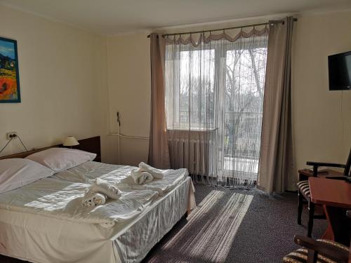 een slaapkamer met een bed met twee handdoeken erop bij Hotel Kakadu in Konin