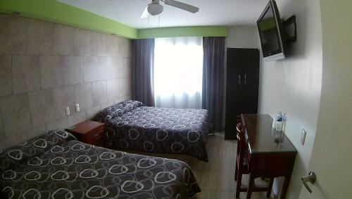 een hotelkamer met twee bedden en een raam bij Hotel San Luis in San Luis Potosí