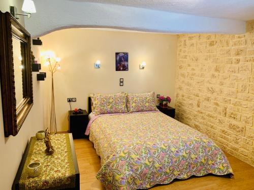 ein Schlafzimmer mit einem Bett und einer Steinmauer in der Unterkunft Ermones Penelope Bungalow in Vátos