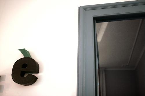 a letter sign on a wall next to a mirror at Albero della fortuna in Turin