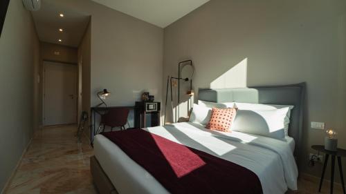 a bedroom with a large bed and a desk at Zefiro Suites in Palermo