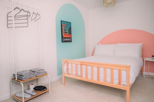 a bedroom with a bed with a wooden headboard at Cozy Stay in Cambridge