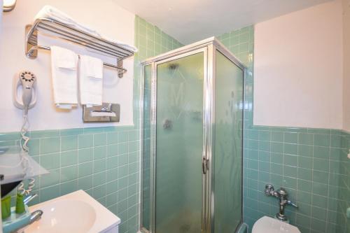 uma casa de banho com um chuveiro e um lavatório. em Monticello Inn- Framingham/ Boston em Framingham