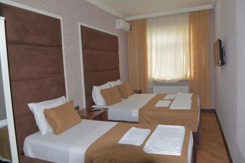 a hotel room with two beds and a window at Viva hotel Gabala with outdoor pool ,Sauna and Waterfall in Gabala