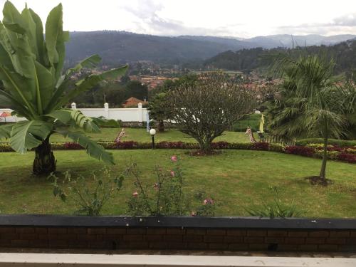 a view of a park with trees and flowers at Kigezi Gardens Inn in Kabale