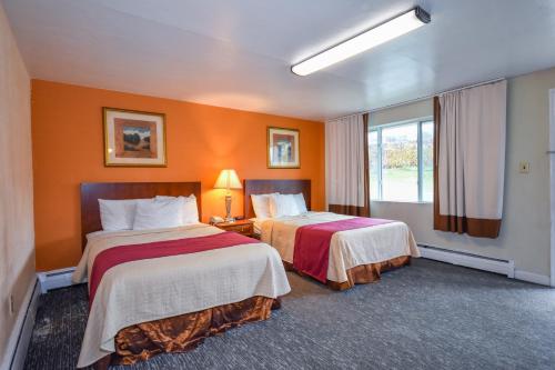 Habitación de hotel con 2 camas y ventana en Monticello Inn- Framingham/ Boston, en Framingham