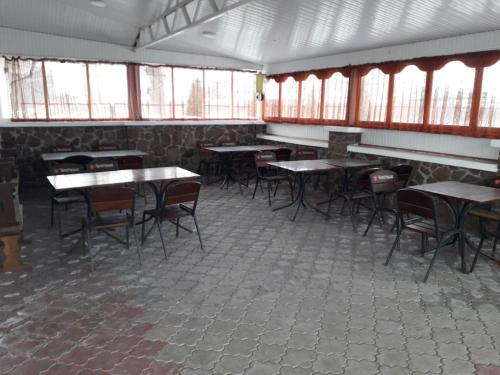 an empty room with tables and chairs and windows at Отель Виктория in Berezyna