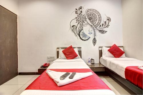 two beds in a room with red and white at Hotel Sunshine Airport in Mumbai