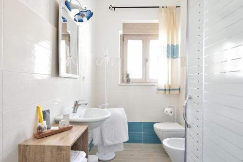 une salle de bain blanche avec un lavabo et des toilettes dans l'établissement INAH Rooms, à Dorgali