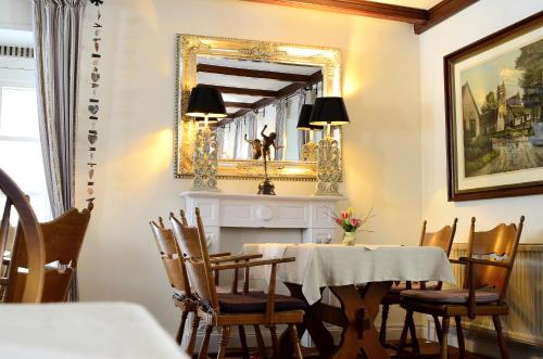 a dining room with a table and a mirror at Hotel Schäferhof in Schneverdingen