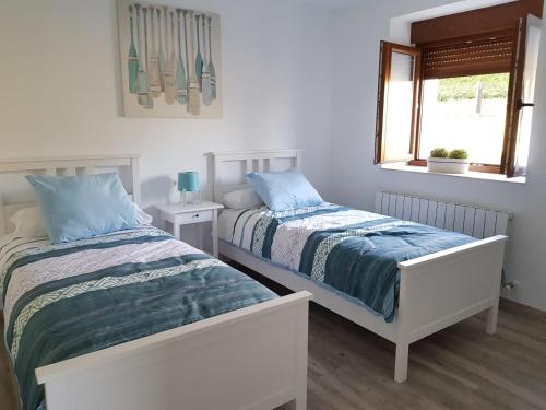 two beds sitting next to each other in a bedroom at Kaltzada Etxea- Busturia in Axpe de Busturia
