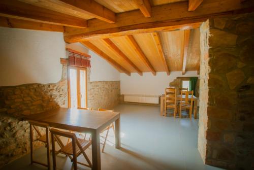 a dining room with a table and chairs in a house at Masia l`Arà in La Baronia de Rialb