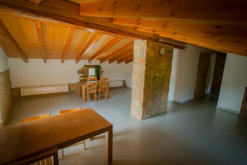 a room with a table and chairs and a stone pillar at Masia l`Arà in La Baronia de Rialb