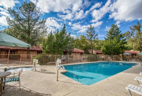 a swimming pool with chairs and a fence at Villas at Poco Diablo, a VRI resort in Sedona