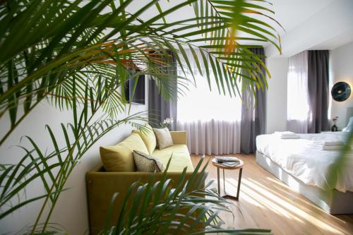 un soggiorno con divano e una grande pianta di Septa Studios by Skg Apartments a Salonicco
