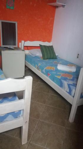 a bedroom with a bed with a laptop on it at Pousada E Restaurante Passart in Morro de São Paulo