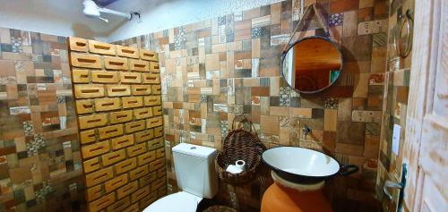 a bathroom with a toilet and a mirror at Vila Aju - Pousada Temática in Aracaju