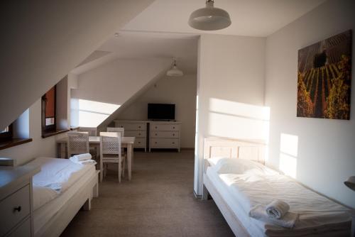 a bedroom with two beds and a dining room at Dvůr Perlová voda in Budyně nad Ohří