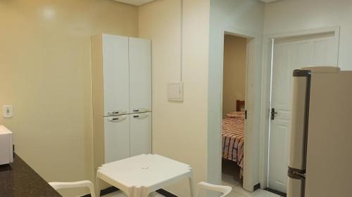 a room with a white cabinet and a table and a bed at Lotus Apartamentos in Santarém