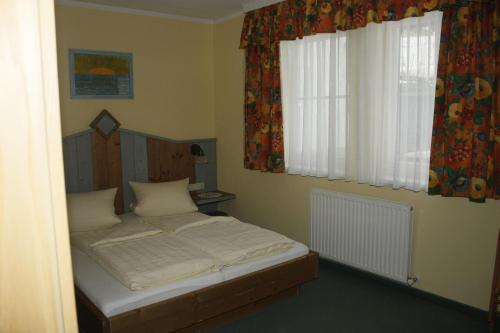 イシュグルにあるApart Ebeneの小さなベッドルーム(ベッド1台、窓付)