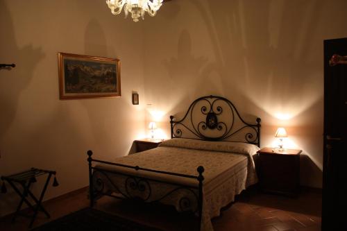 Serra deʼ ContiにあるIl Pozzo di Vivalpaのベッドルーム1室(ベッド1台、ランプ2つ、テーブル2台付)