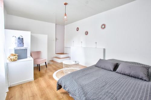 - une chambre blanche avec un lit et une table dans l'établissement Maison cosy et paisible au coeur de Beauvais, à Beauvais